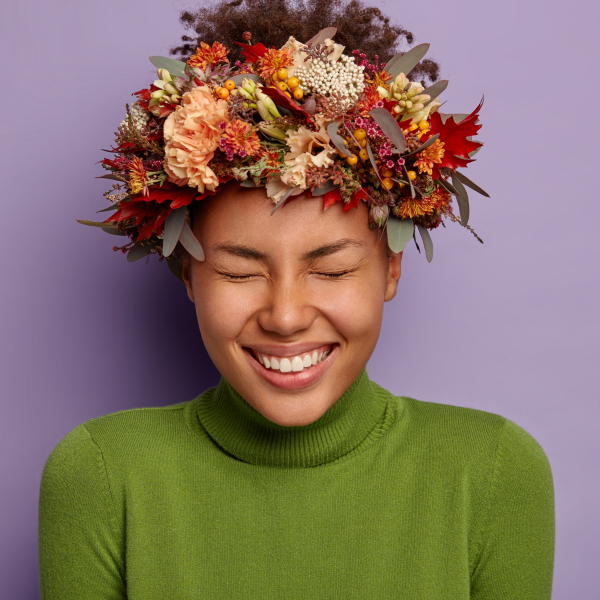 Mulher com coroa de flores na cabeça sorrindo